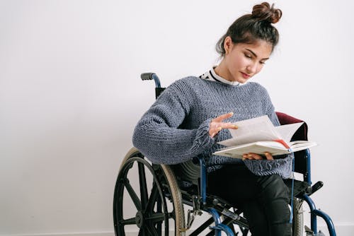 Image Free A Woman in a Sweater Reading a Book Stock Photo