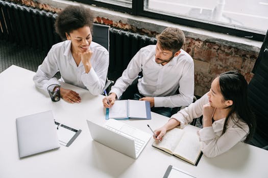 A diverse team of professionals collaborating in an office setting, engaging in a productive meeting.