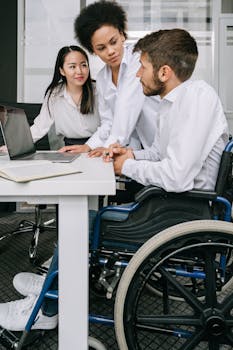 A diverse team of professionals in a wheelchair-accessible office, collaborating on business strategies.