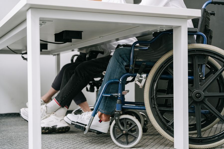 Persona en silla de ruedas acompañada por un cuidador