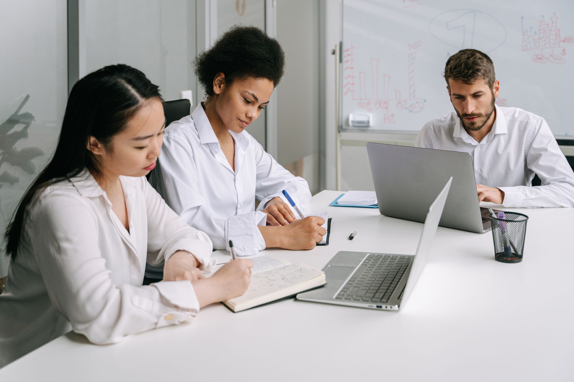 A diverse group of professionals engaged in teamwork and collaboration in a modern office environment.