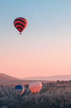 Colorful hot air balloons soar over the stunning landscapes of Cappadocia at sunrise.
