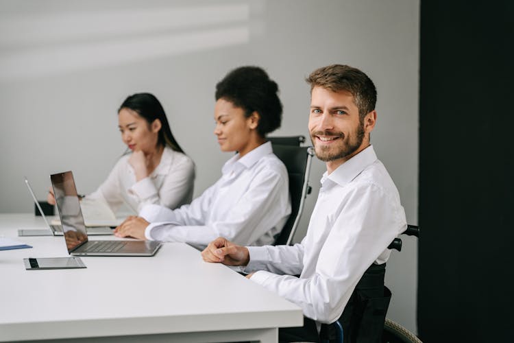 Man Sitting At A Table With Laptop