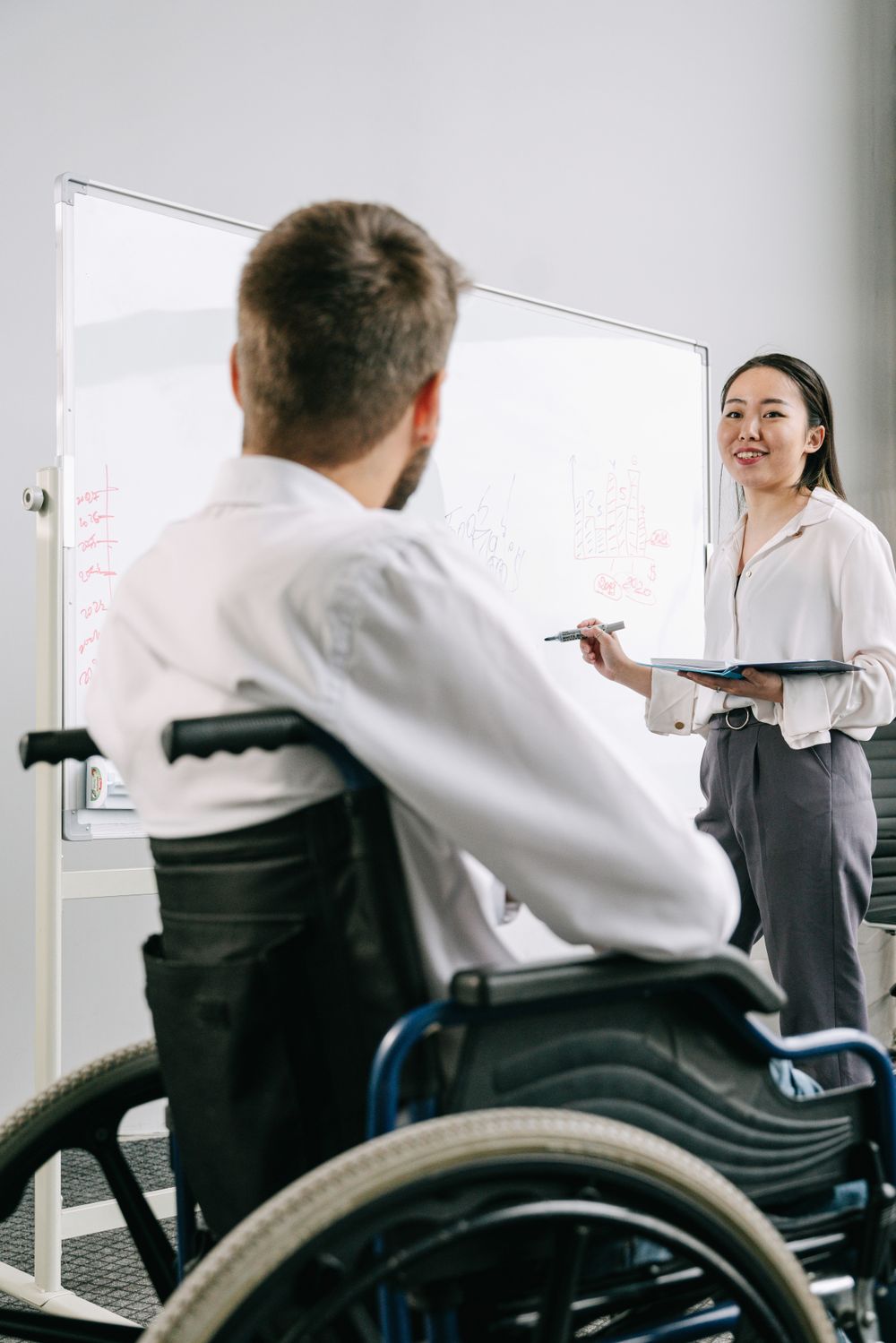 Two colleagues planning at a whiteboard, photo by Ivan S on Pexels