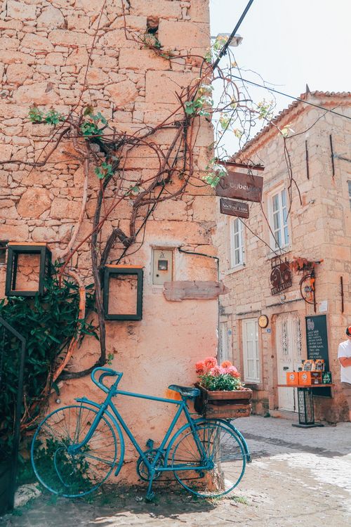 Free Explore a picturesque stone alley with a vintage bicycle and colorful flowers, perfect for urban travel themes. Stock Photo