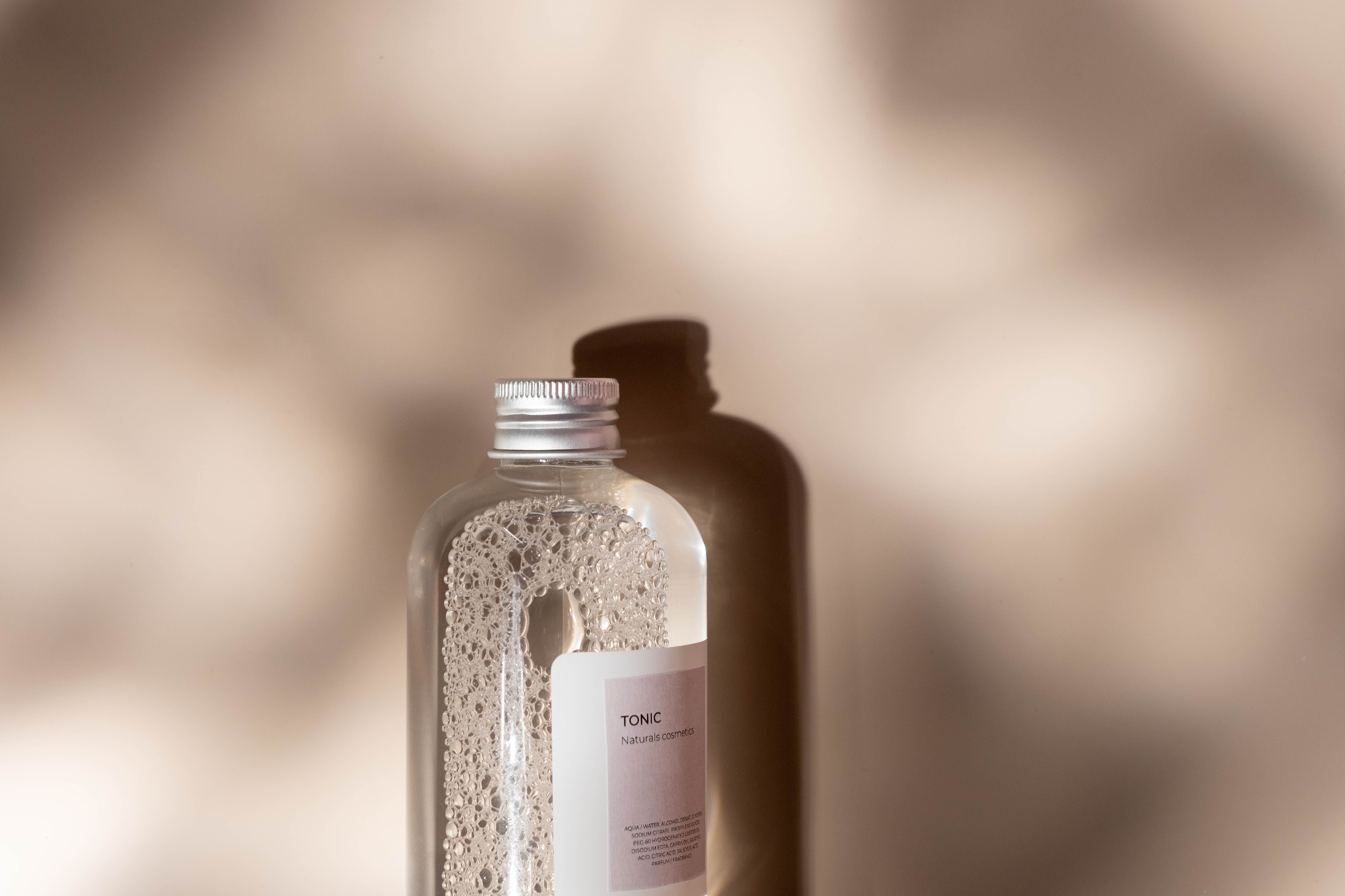 Application d'une crème hydratante visage sur le visage d'une femme aux peaux brillante