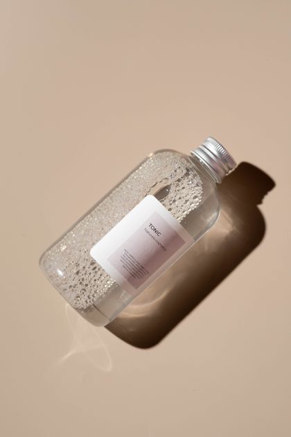 Garrafa de água tônica sobre superfície neutra