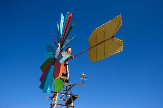 Bright, colorful windmill set against a clear blue sky, symbolizing renewable energy and innovation.