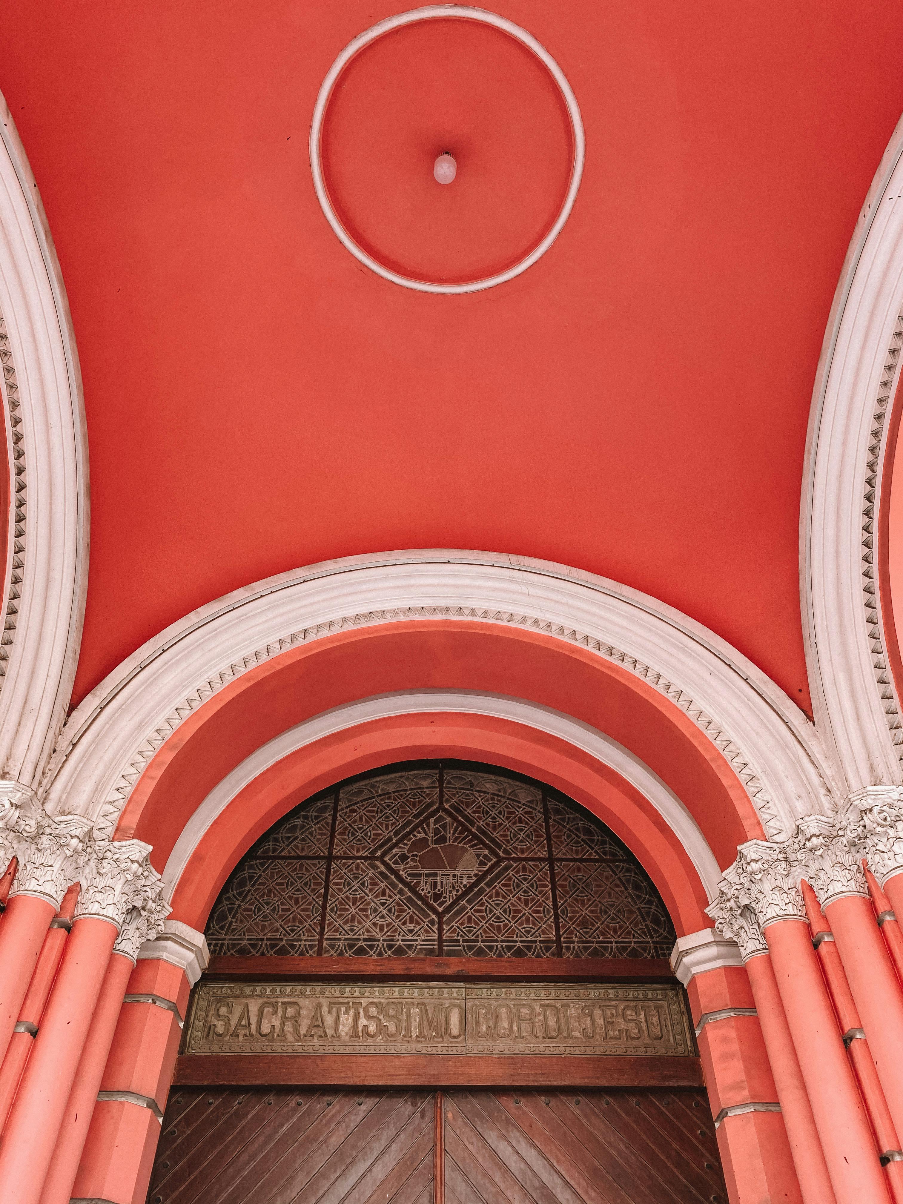 Low angle shot of an ornate, pink archway with classic architectural elements.