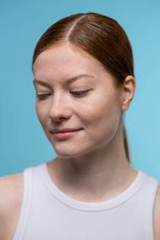 Close-up of a woman with natural beauty and freckles in a studio setting.