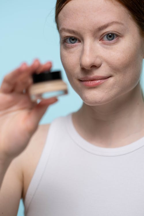 Woman in White Tank Top Holding A Concealer