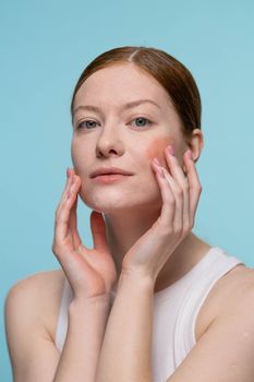Studio portrait of a woman showcasing natural beauty with minimal makeup and a calm expression.