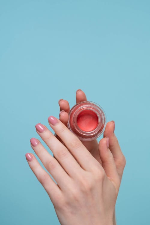 Person Holding Round Pink Plastic Container