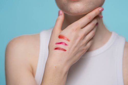 Free Crop Photo Of Woman in White Tank Top With Different Shades Of Red Lipstick On Hand Stock Photo