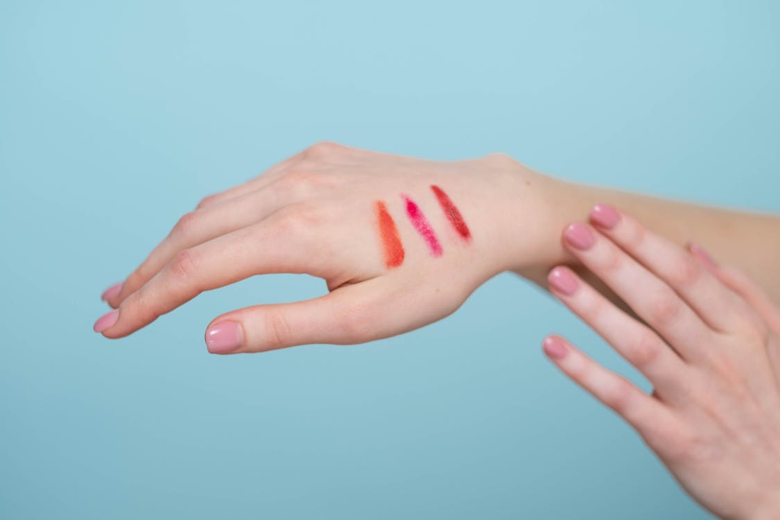 Free Persons Hand With Different Shades Of Lipstick Stock Photo