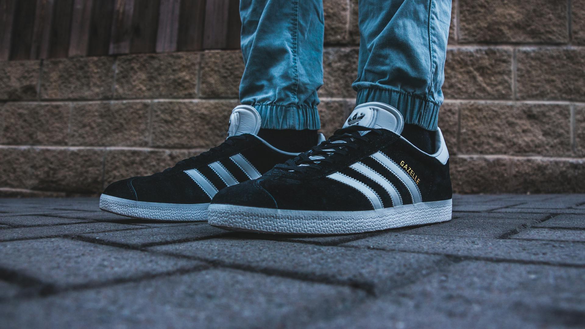 A detailed close-up of trendy Adidas sneakers on an urban pavement.