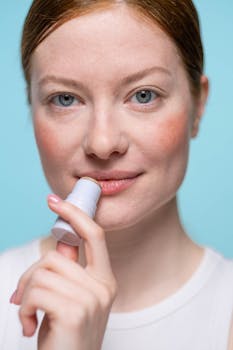 Close-up portrait of a woman applying lip balm, highlighting skincare routine.