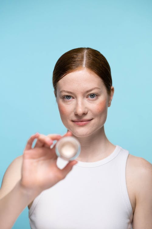 Woman in White Tank Top Holding A Concealer