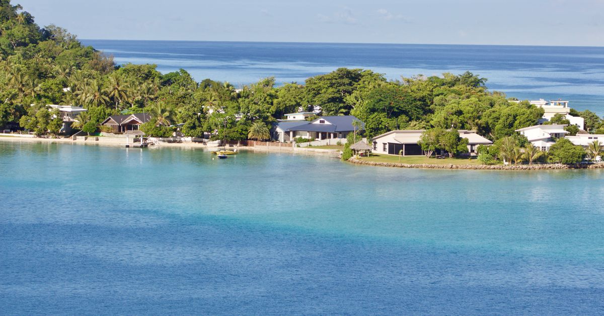 Scenic view of a tropical island resort with clear blue waters and lush greenery, ideal for vacations.