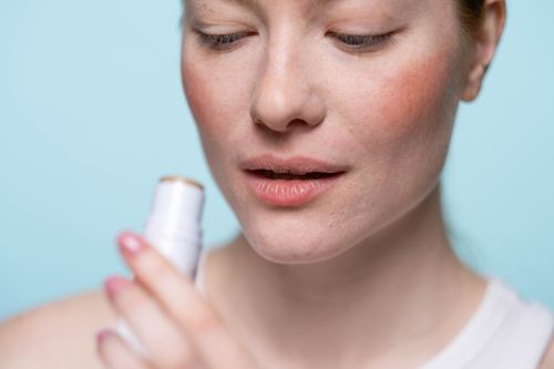 Free Close-up of a woman applying lip balm indoors. Ideal for skincare and beauty themes. Stock Photo