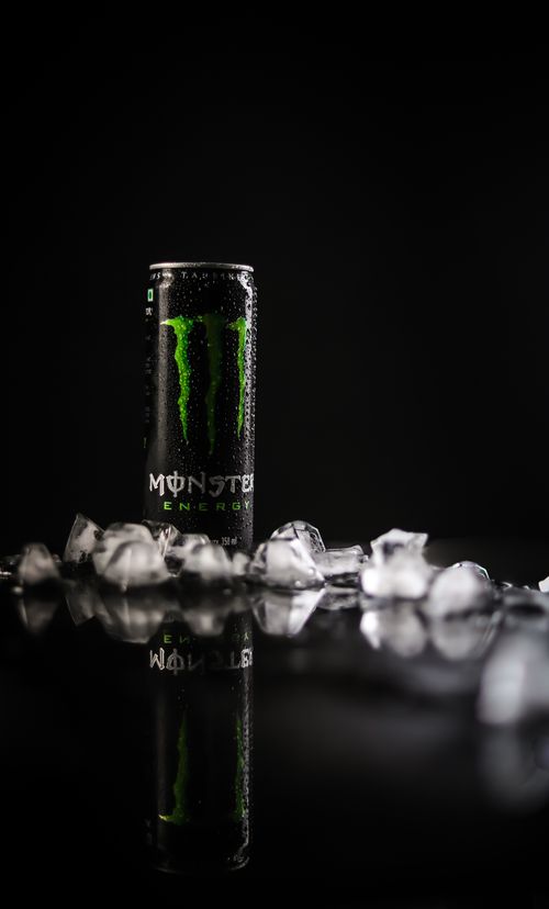 Free Artistic photo of a chilled energy drink can surrounded by ice cubes on a reflective black surface. Stock Photo