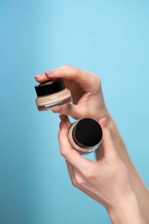 Free Person Holding Two Concealers Stock Photo