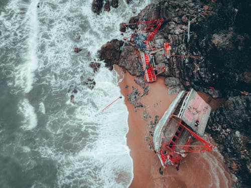 Red Boat Crashed on Rocky Seashore