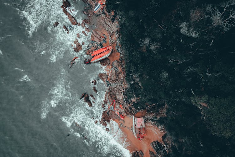 Orange Boat Crashed On The Rocky Shoreline