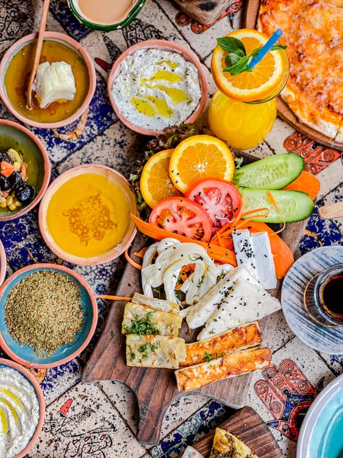 Free Vibrant Mediterranean brunch spread with fruits, veggies, and assorted dishes in an artistic setting. Stock Photo