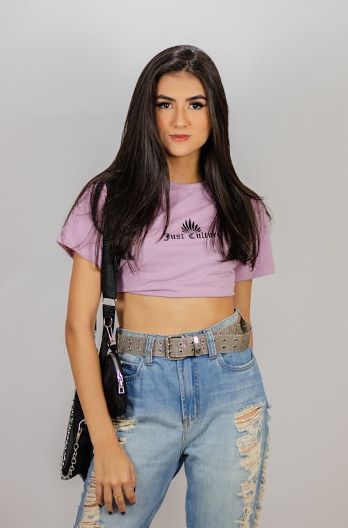 Free A Person in Purple Crop Top Shirt and Blue Denim Jeans Stock Photo