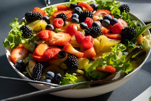 Colorful salad with fresh strawberries, blueberries, and greens, perfect for a healthy lifestyle.