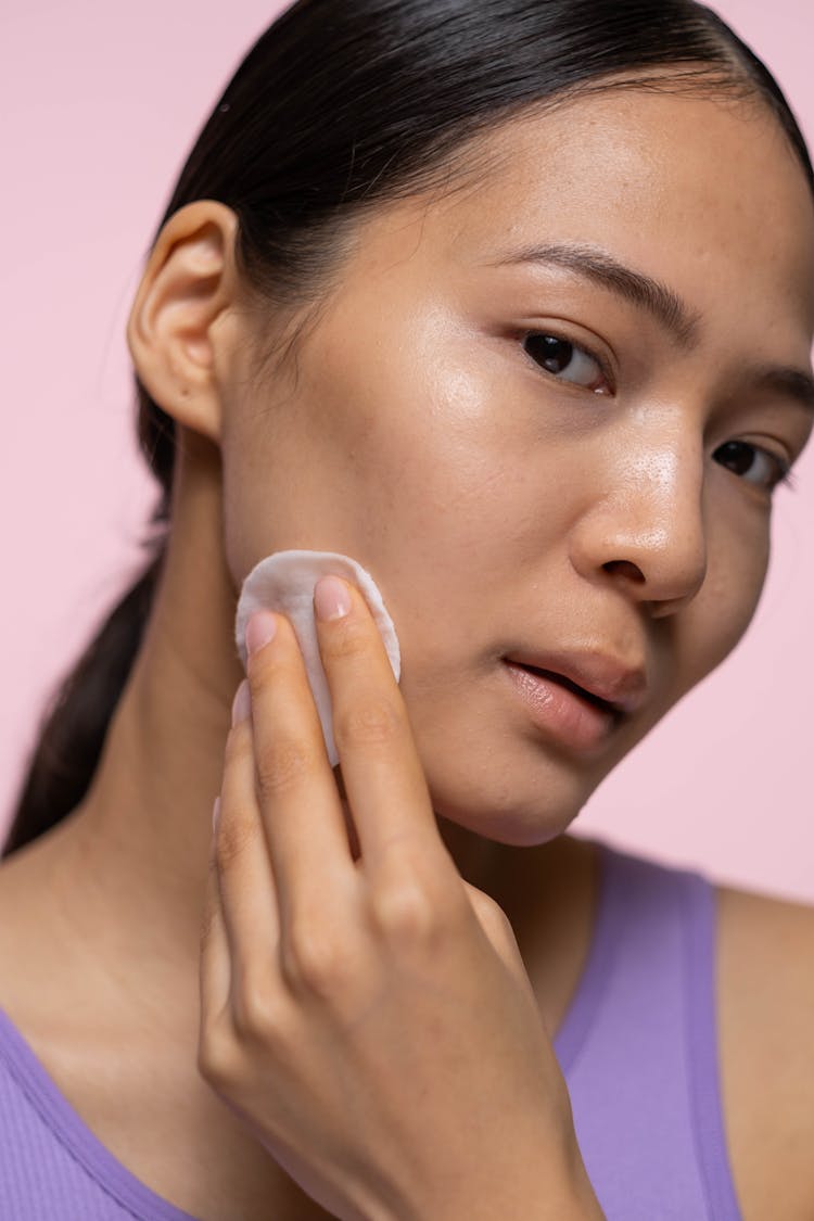 Woman In Purple Tank Top Applying Facial Tonic 