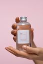 Person Holding a Glass Bottle With Tonic