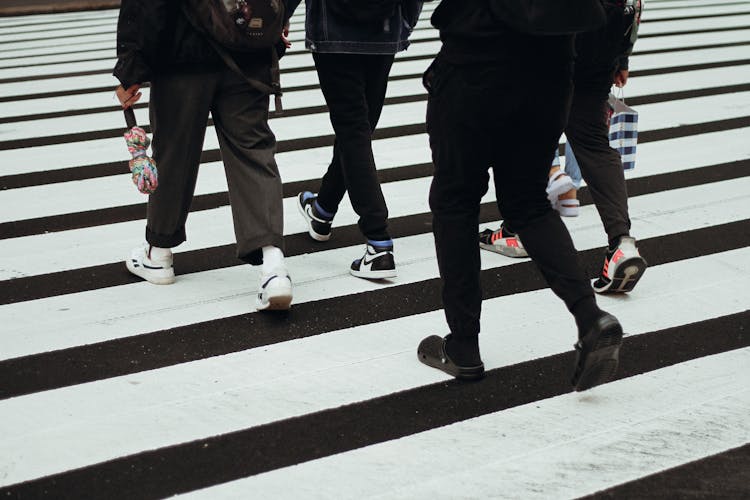 People Walking On Pedestrian Crossing In Daytime