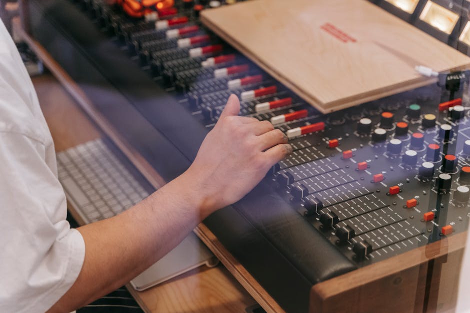 Hand of a Person Operating a Sound Mixer