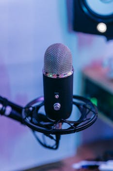 A detailed view of a condenser microphone with pop filter in a modern music studio.