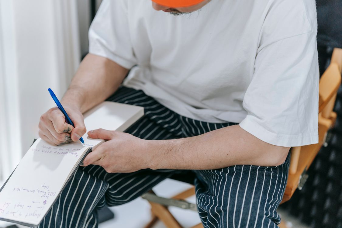Man Writing on Notepad with a Pen · Free Stock Photo