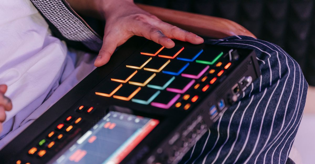 Close-up of hands on music production equipment in a studio setting in Ghana