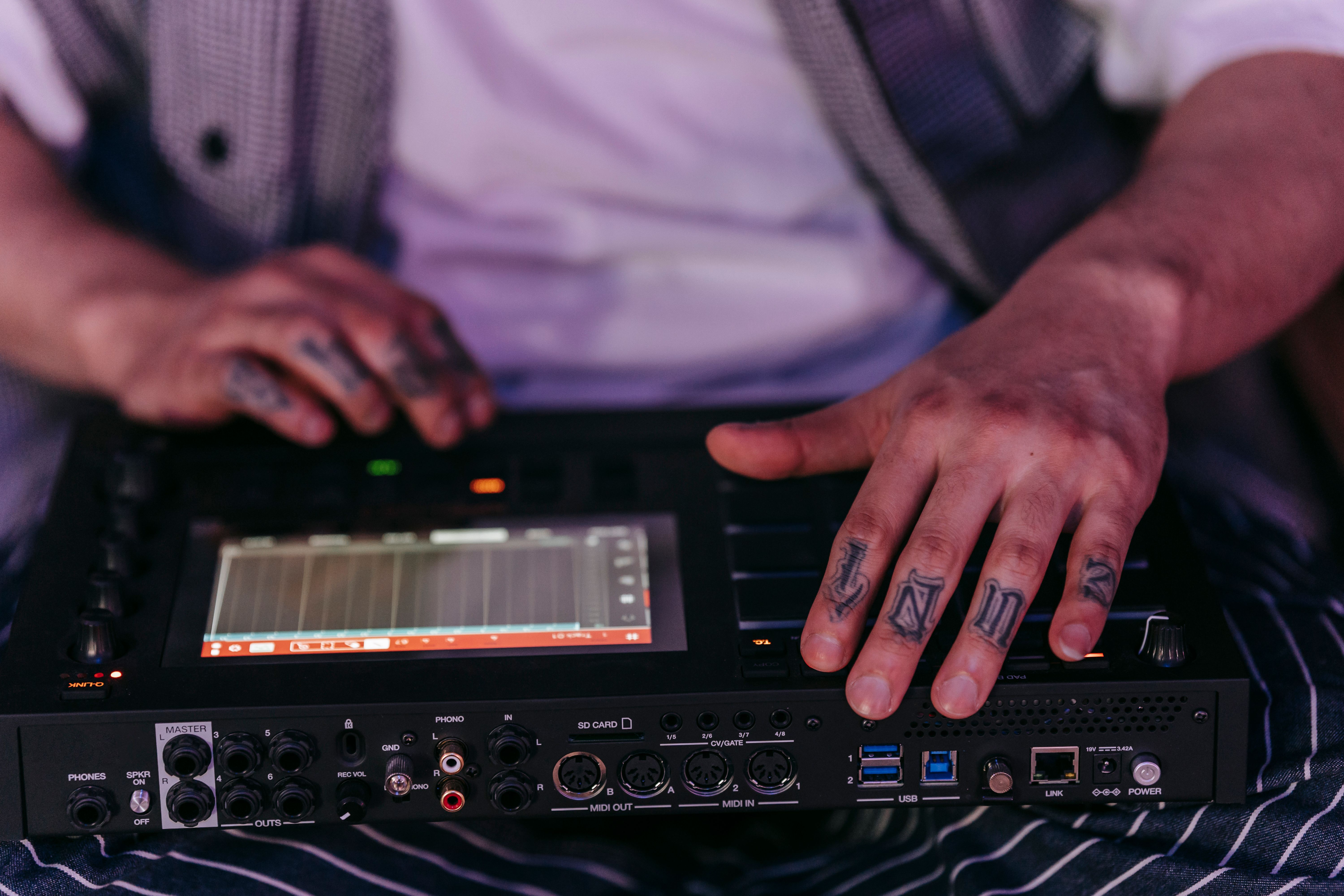 A close-up shot of a musician's hands on a mixing board with a digital overlay of code and waveforms