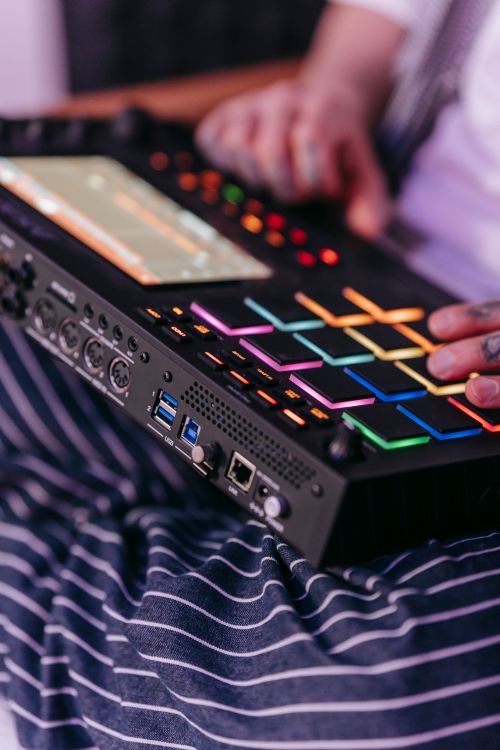 Free A close-up view of hands operating a colorful music sequencer indoors. Stock Photo