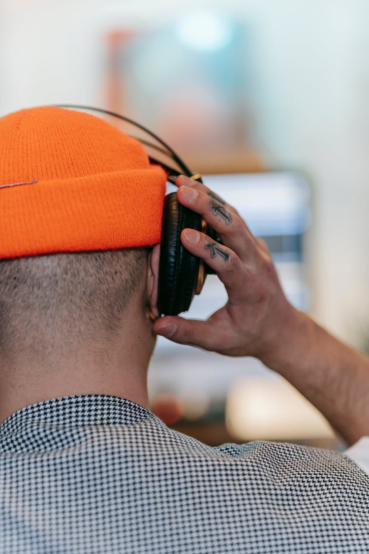 Person With Hand Tattoos Listening To The Headphones