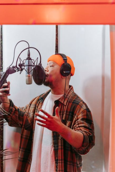 A male singer passionately recording vocals in a modern recording studio.