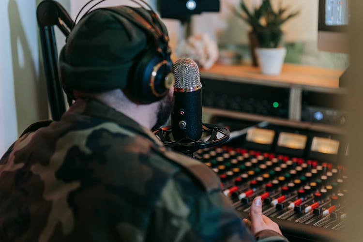 Man In Headphones Recording In Music Studio