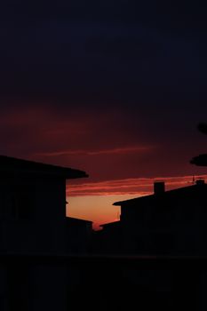 Silhouetted buildings against a vibrant sunset sky create a dramatic urban scene.