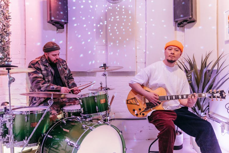 Two Men Playing Drums And Electric Guitar 