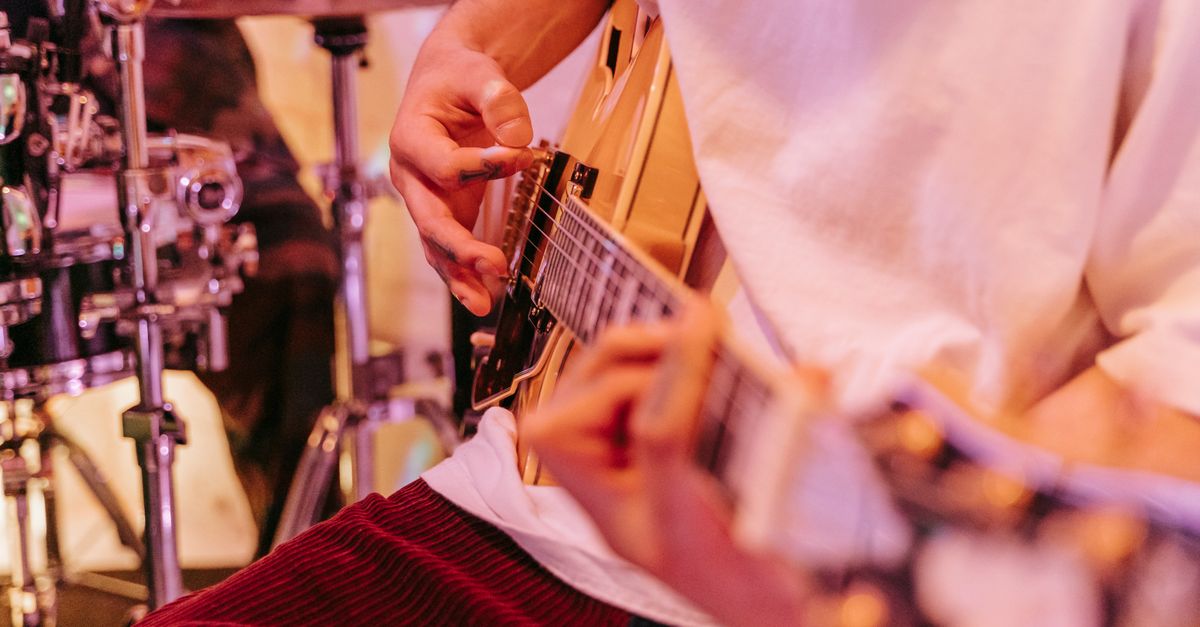 Close-up of a worship band playing guitars and drums inside Loveworld Arena