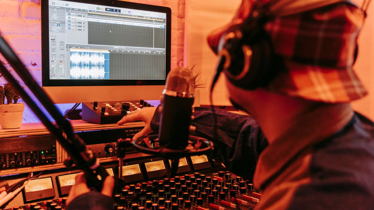 Music producer working in a studio with computer and mixing equipment