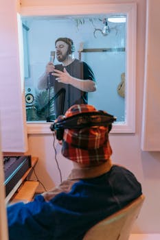 Musician recording vocals in a soundproof music studio setting.