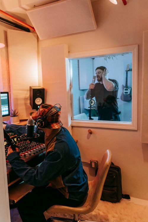 Free A vibrant scene in a music studio with two men collaborating on a recording session. Stock Photo