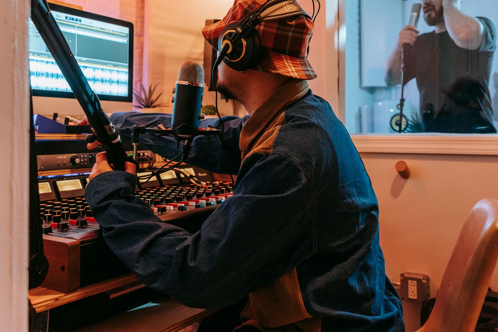 Productor y artista trabajando juntos en un estudio profesional creando un beat tag
